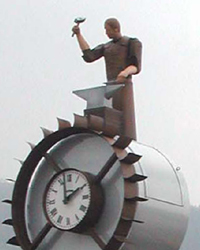 Michell HARTMANN - Forgeron de Thiers, 270 x 860 x 155 cm., 2008, acier Corten et aluminium, Jaquemart et fontaine à 12 mouvements. Michell HARTMANN - Forgeron de Thiers, 270 x 860 x 155 cm., 2008, acier Corten et aluminium, Jaquemart et fontaine à 12 mouvements.